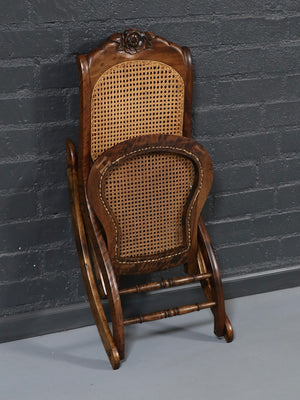 American Victorian Folding Cane Rocking Chair w/ Carved Rose Crest, c.1920's